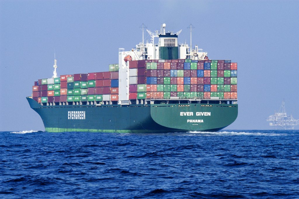 A large container ship sails away packed with intermodal containers