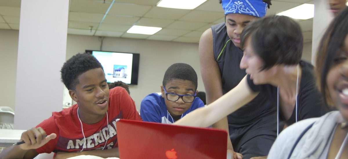 day2-008 Lessons in energy science, technology, and art Model during the 2015 Art+Energy Camp. In this photo we see Elizabeth Monoian sharing information with a group of students around a table.