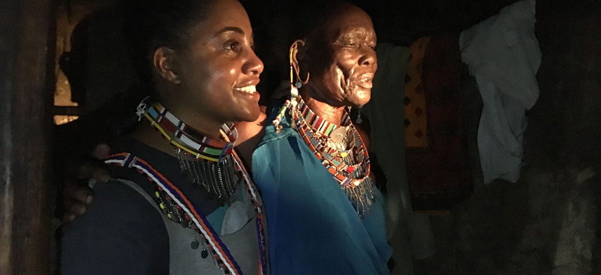 img_4521 Tereneh Mosley visits the manyatta of Leah Tale, who is the oldest member of OMWA. Tale made all of the jewelry that both women are wearing. After initial design sessions with Idia'Dega two years ago, Tale has expressed her interest in expanding her designs outside of traditional patterns, including the development of the new design seen here in the chocker Tereneh is wearing. You can also see from this photo how very little light there is in a home during the day. The only light here is thrown from another camera flash.